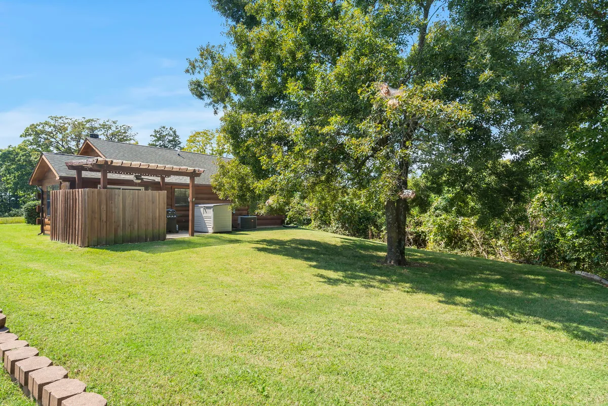This image shows a charming exterior view featuring a large tree, a wooden fence, and a welcoming house with a spacious porch. The scene is lively with activities such as gardening, outdoor gatherings, and children playing, all set in a relaxed atmosphere ideal for post-golf relaxation.